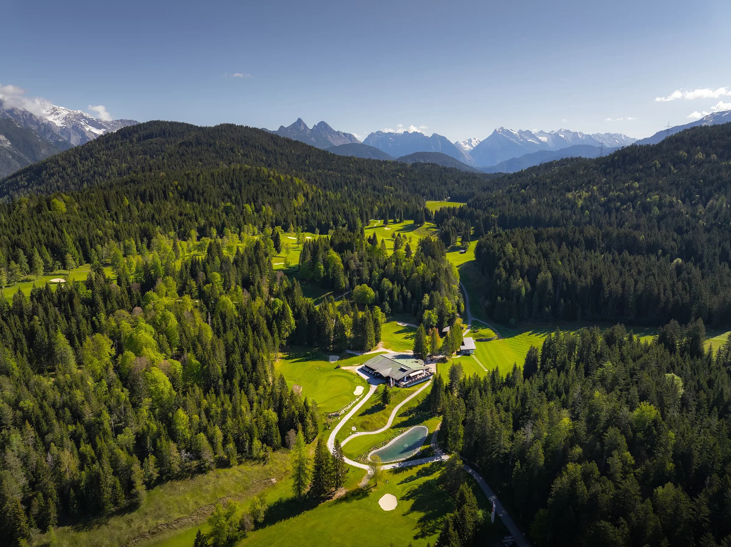 Drohnenaufnahme des Restaurants im Golfclub Wildmoos mit den Arnspitzen im Hintergrund