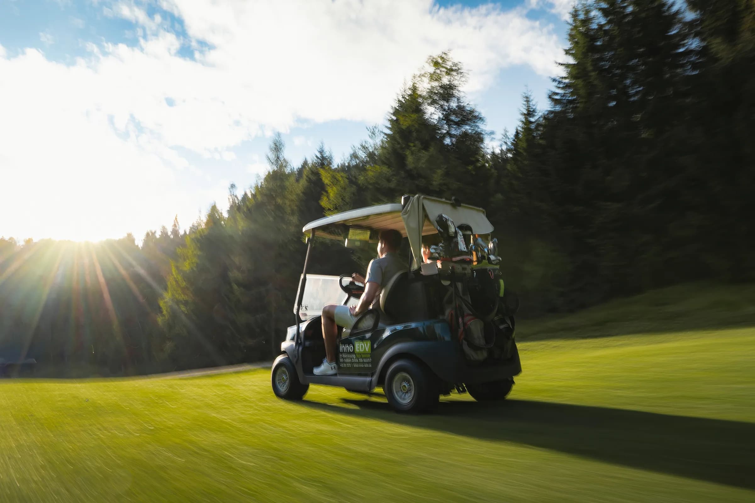 Mitzieher-Aufnahme eines Golf-Carts im Golfclub Wildmoos bei Sonnenuntergang